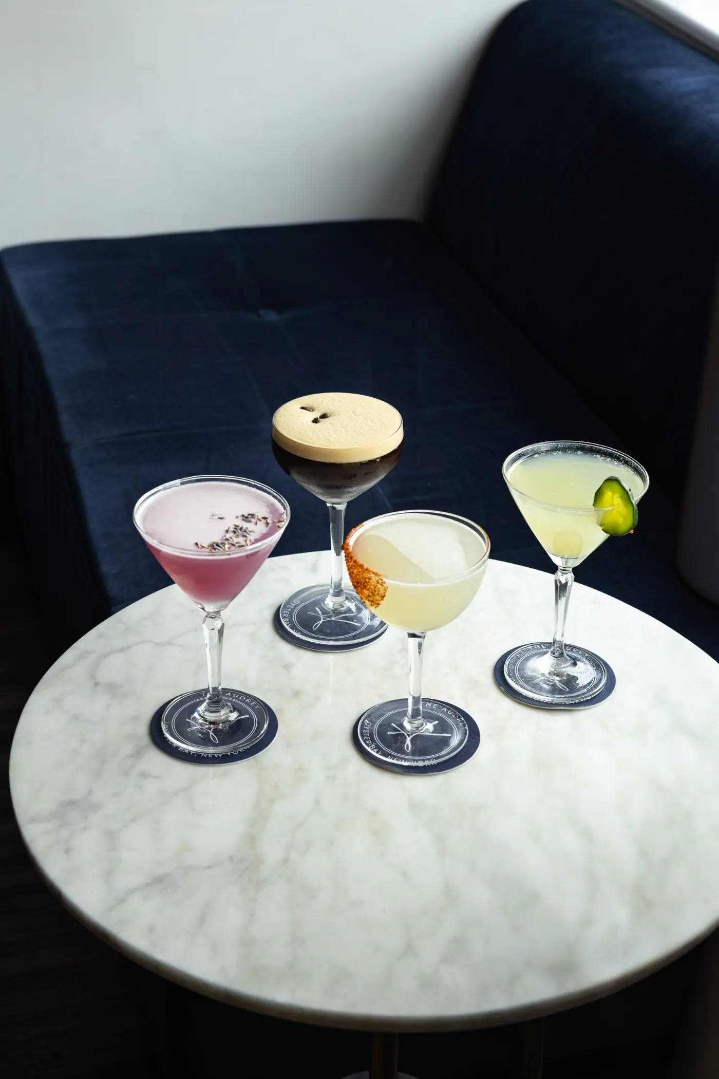 Four cocktails on a marble table
