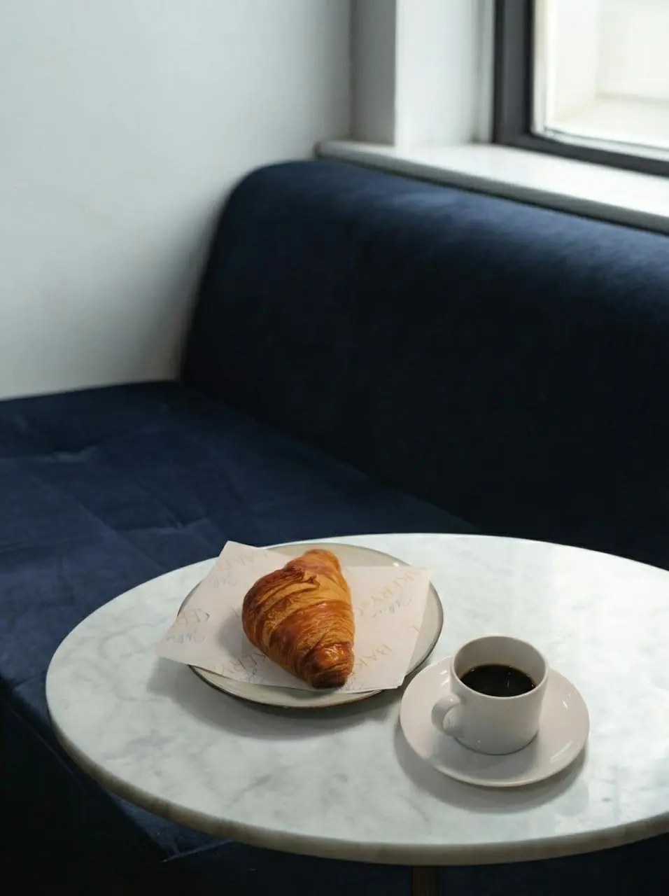 A coffee and a pastry on marble